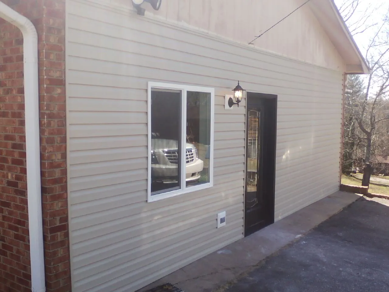 New vinyl siding and entry door on a room addition in Piffard