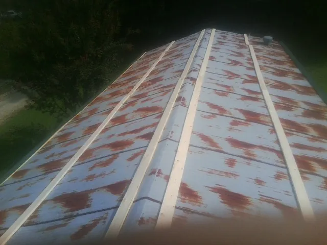 Rusted metal roof panels with new wood purlins before replacement — Storm Damage Roof Repair in Piffard by Roofing Brothers